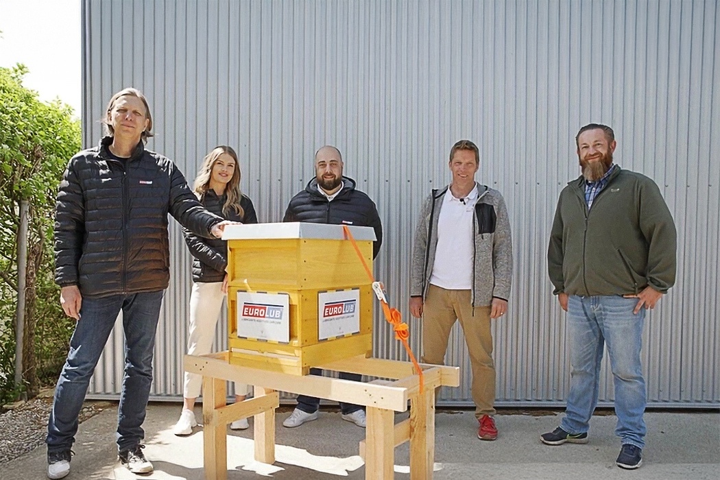 Der CEO und das Team von EUROLUB präsentieren einen Bienenstock auf dem Firmengelände